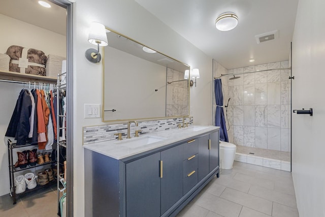 bathroom with a shower stall, visible vents, backsplash, and a sink