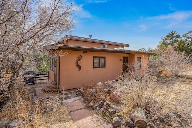 exterior space with stucco siding and fence