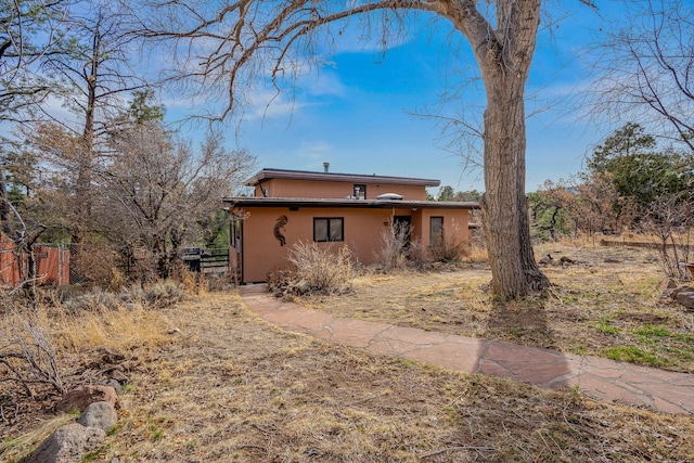 exterior space with stucco siding and fence