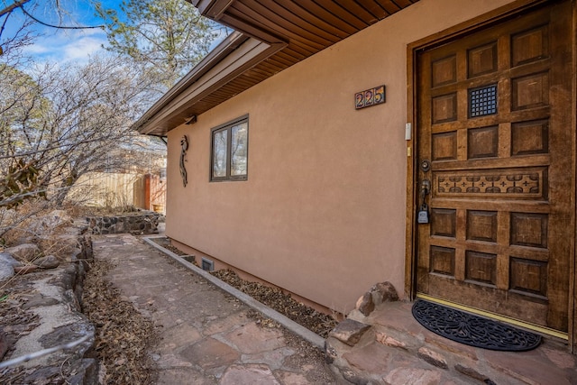 entrance to property featuring stucco siding