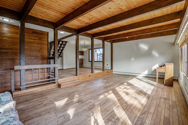 unfurnished living room with hardwood / wood-style floors, beam ceiling, stairs, and a baseboard radiator