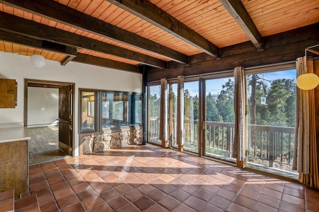 unfurnished sunroom featuring beam ceiling, plenty of natural light, and wooden ceiling