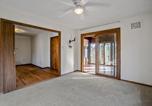 carpeted empty room featuring a ceiling fan, baseboards, and visible vents