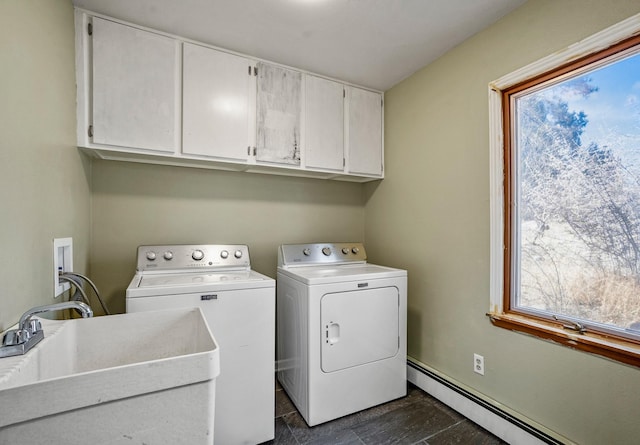 laundry area with a sink, a baseboard heating unit, cabinet space, and washing machine and dryer