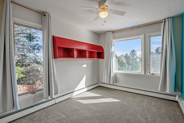 carpeted empty room featuring a baseboard heating unit and a ceiling fan