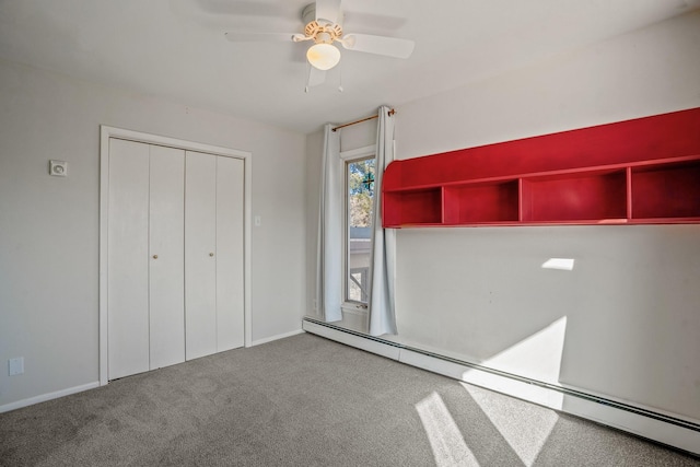 unfurnished bedroom featuring a baseboard heating unit, carpet floors, a closet, and ceiling fan