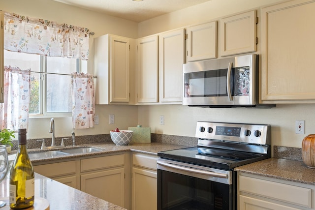 kitchen featuring a sink, stone countertops, and appliances with stainless steel finishes