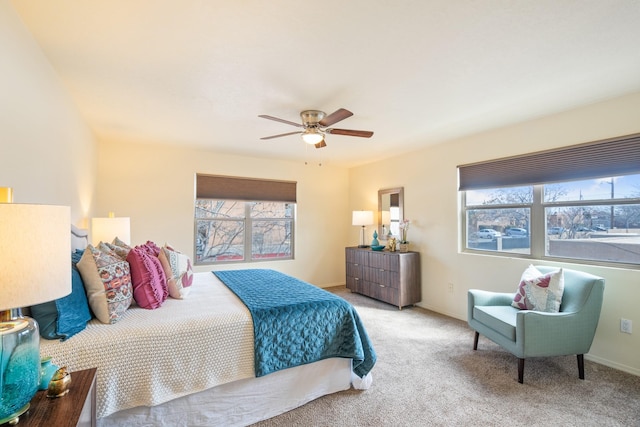 carpeted bedroom with multiple windows, a ceiling fan, and baseboards