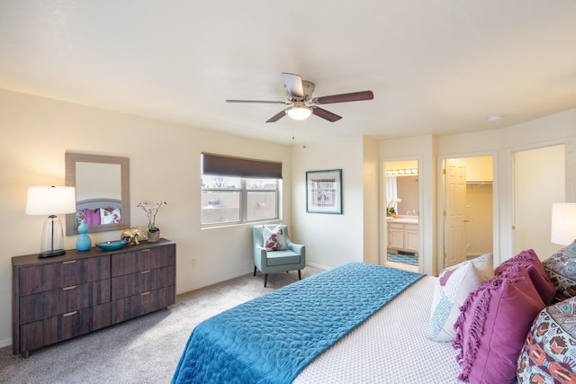 carpeted bedroom with a ceiling fan, baseboards, and ensuite bathroom