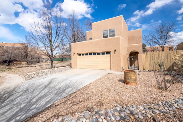 adobe home with fence, concrete driveway, stucco siding, a garage, and a gate