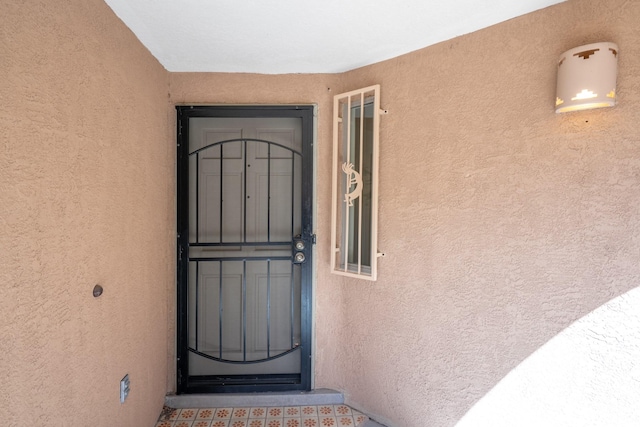 entrance to property featuring stucco siding