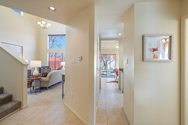 corridor featuring a wealth of natural light, light tile patterned floors, recessed lighting, and stairs