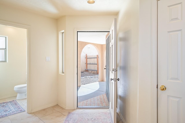 interior space with light tile patterned floors, baseboards, and a healthy amount of sunlight