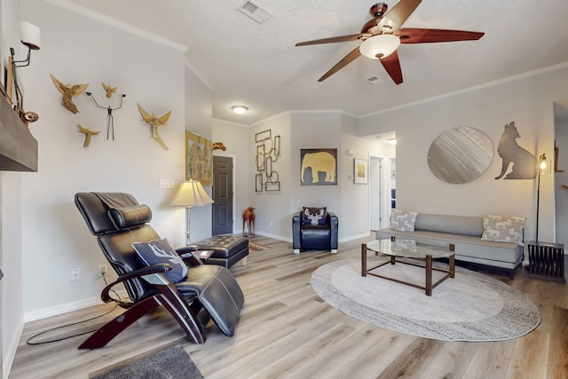 living area featuring visible vents, crown molding, baseboards, and wood finished floors