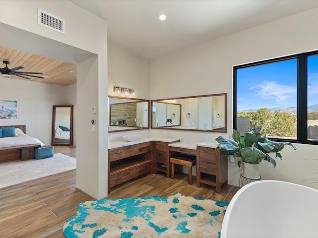 full bathroom featuring a freestanding tub, visible vents, wood finished floors, and vanity