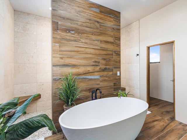 bathroom featuring wood finished floors and a freestanding bath