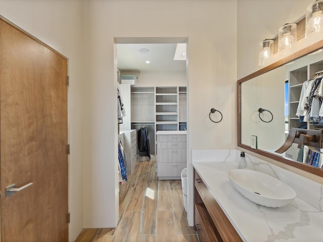 bathroom featuring vanity, a spacious closet, and wood finished floors