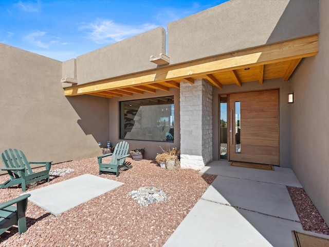 view of exterior entry featuring stucco siding