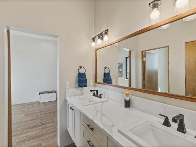 full bathroom featuring a sink, wood finish floors, and double vanity