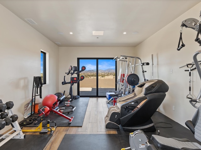 workout area with visible vents, recessed lighting, and wood finished floors