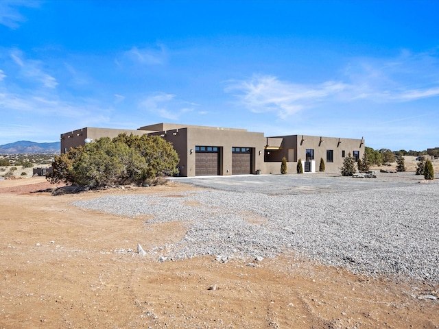 view of front of property with a garage, driveway, and stucco siding