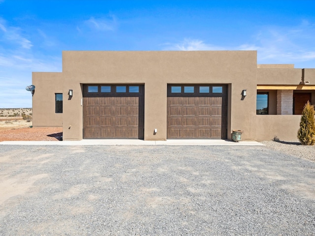 view of front of home with a garage and stucco siding