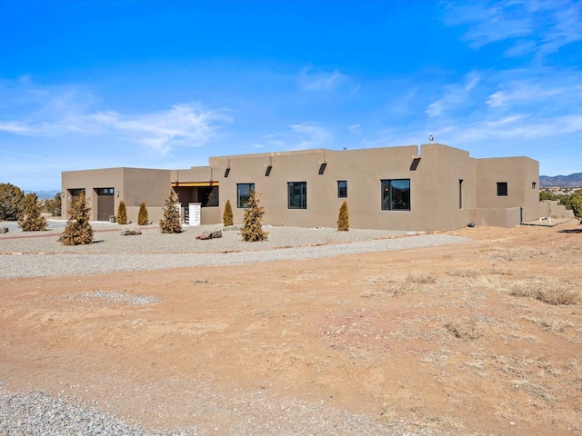 rear view of property featuring stucco siding