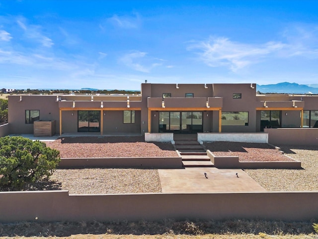 back of house featuring a mountain view and stucco siding