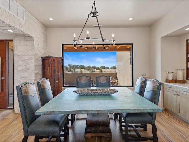 dining area featuring light wood-type flooring, visible vents, and a notable chandelier