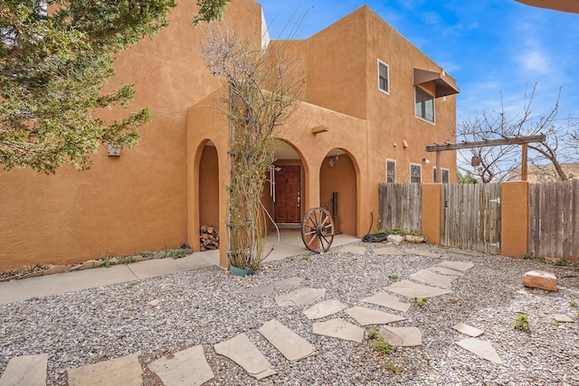 view of front of property featuring fence and stucco siding