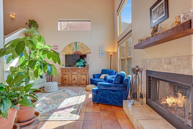 living room featuring tile patterned flooring, a towering ceiling, and a tile fireplace