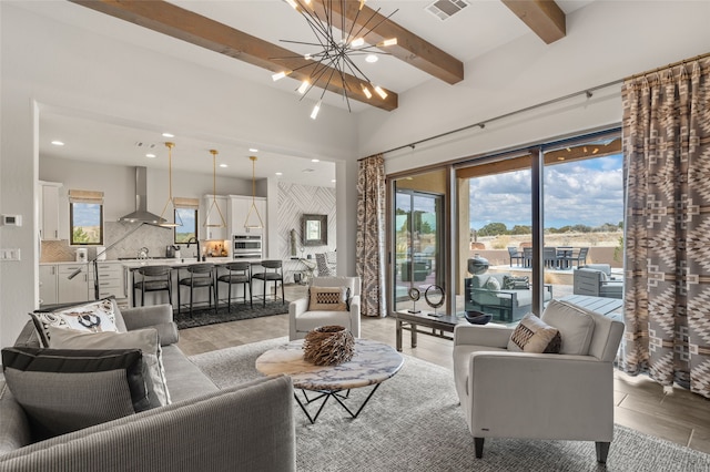 living area featuring recessed lighting, beamed ceiling, a notable chandelier, and visible vents