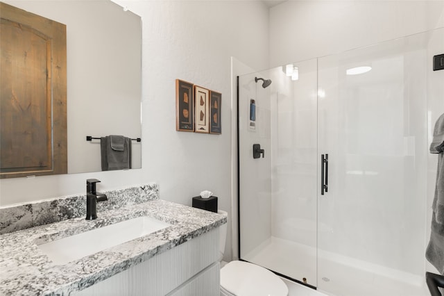 bathroom with vanity, toilet, and a stall shower