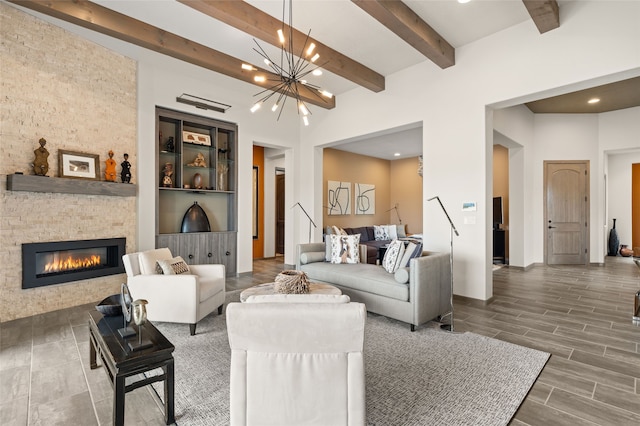 living room featuring beam ceiling, a notable chandelier, a stone fireplace, and wood tiled floor