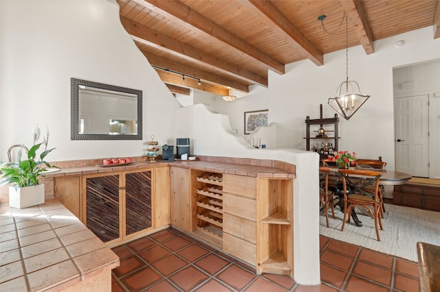 bar with beam ceiling, tile patterned flooring, wood ceiling, and a chandelier