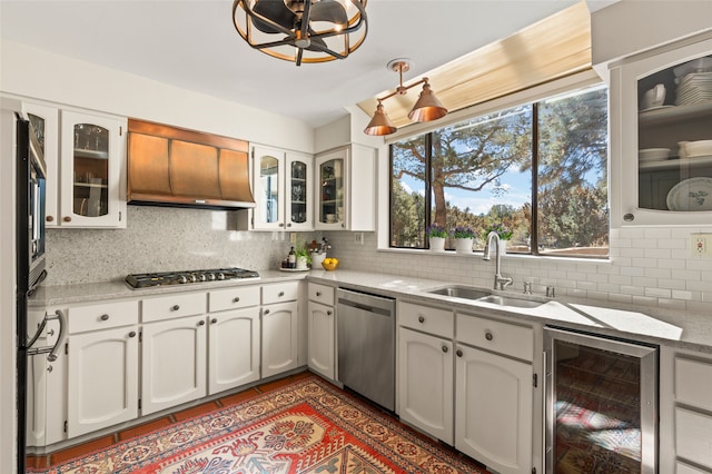 kitchen featuring a sink, stainless steel appliances, backsplash, and beverage cooler