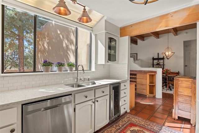 kitchen with tile patterned floors, a sink, white cabinets, decorative backsplash, and dishwasher