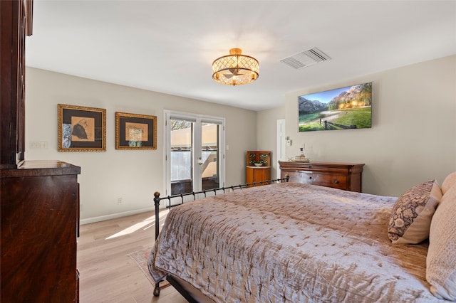 bedroom featuring light wood finished floors, visible vents, baseboards, and access to outside