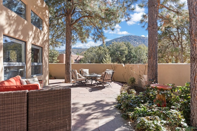 view of patio / terrace with fence and a mountain view