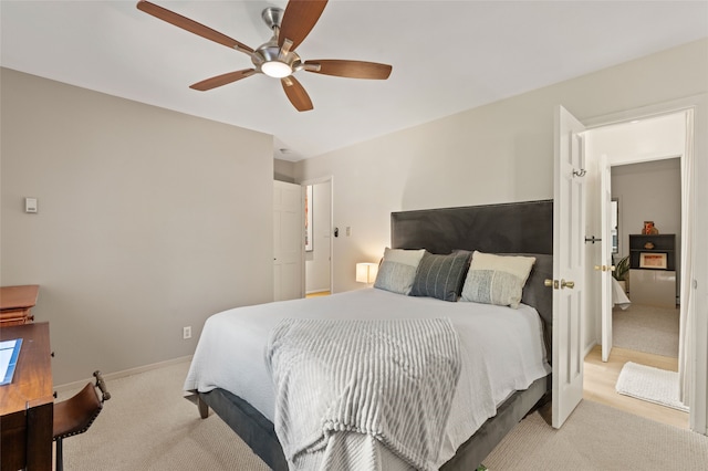 bedroom with light colored carpet, baseboards, and ceiling fan