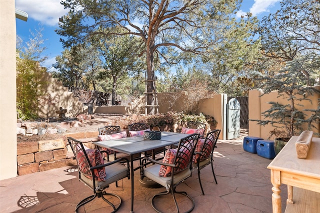 view of patio / terrace featuring outdoor dining area, fence private yard, and a gate