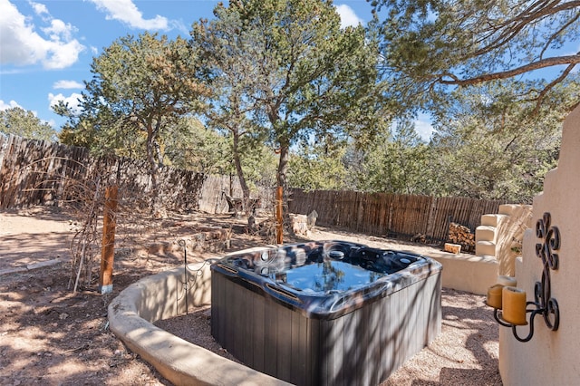 exterior space featuring a hot tub and a fenced backyard