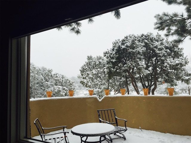 view of snow covered back of property