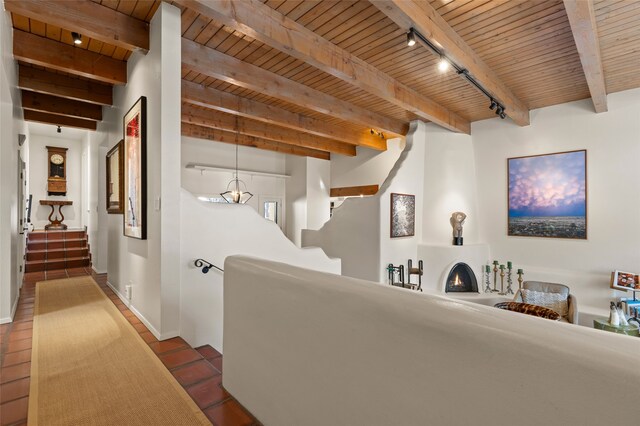 corridor with beam ceiling, wooden ceiling, and rail lighting