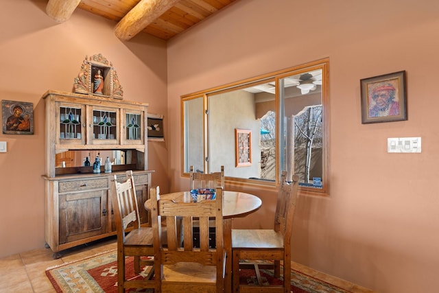 dining area featuring light tile patterned floors, beamed ceiling, and wooden ceiling