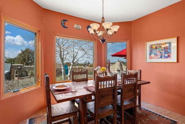 dining area featuring tile patterned floors and an inviting chandelier