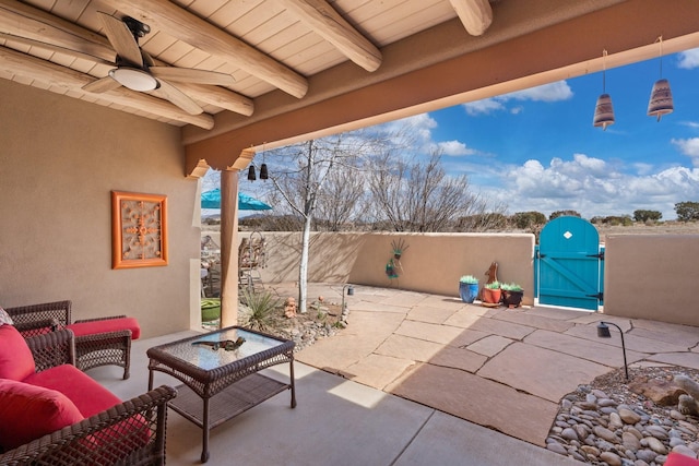 view of patio with fence, ceiling fan, outdoor lounge area, and a gate