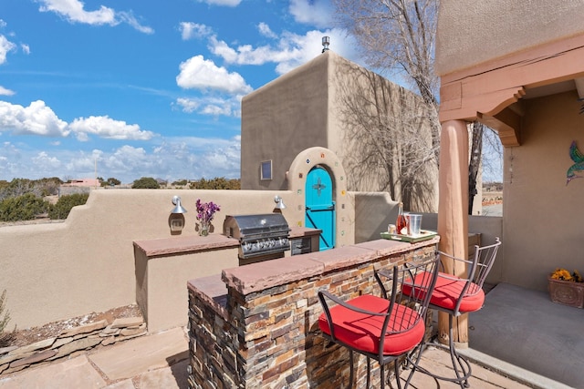 view of patio / terrace featuring outdoor wet bar, exterior kitchen, and area for grilling