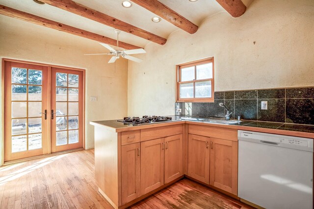 kitchen with light wood-style flooring, gas stovetop, white dishwasher, a sink, and french doors