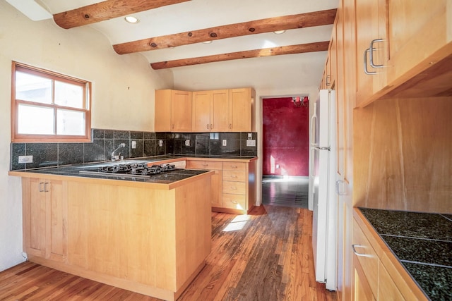 kitchen with light brown cabinetry, black gas cooktop, decorative backsplash, a peninsula, and freestanding refrigerator